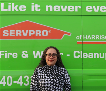 female employee in front of a SERVPRO® van