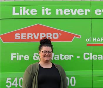 female employee standing in front of a SERVPRO® van