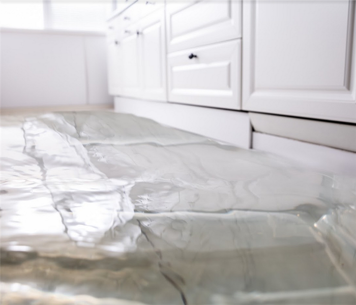 a flooded kitchen with water covering the tile floor